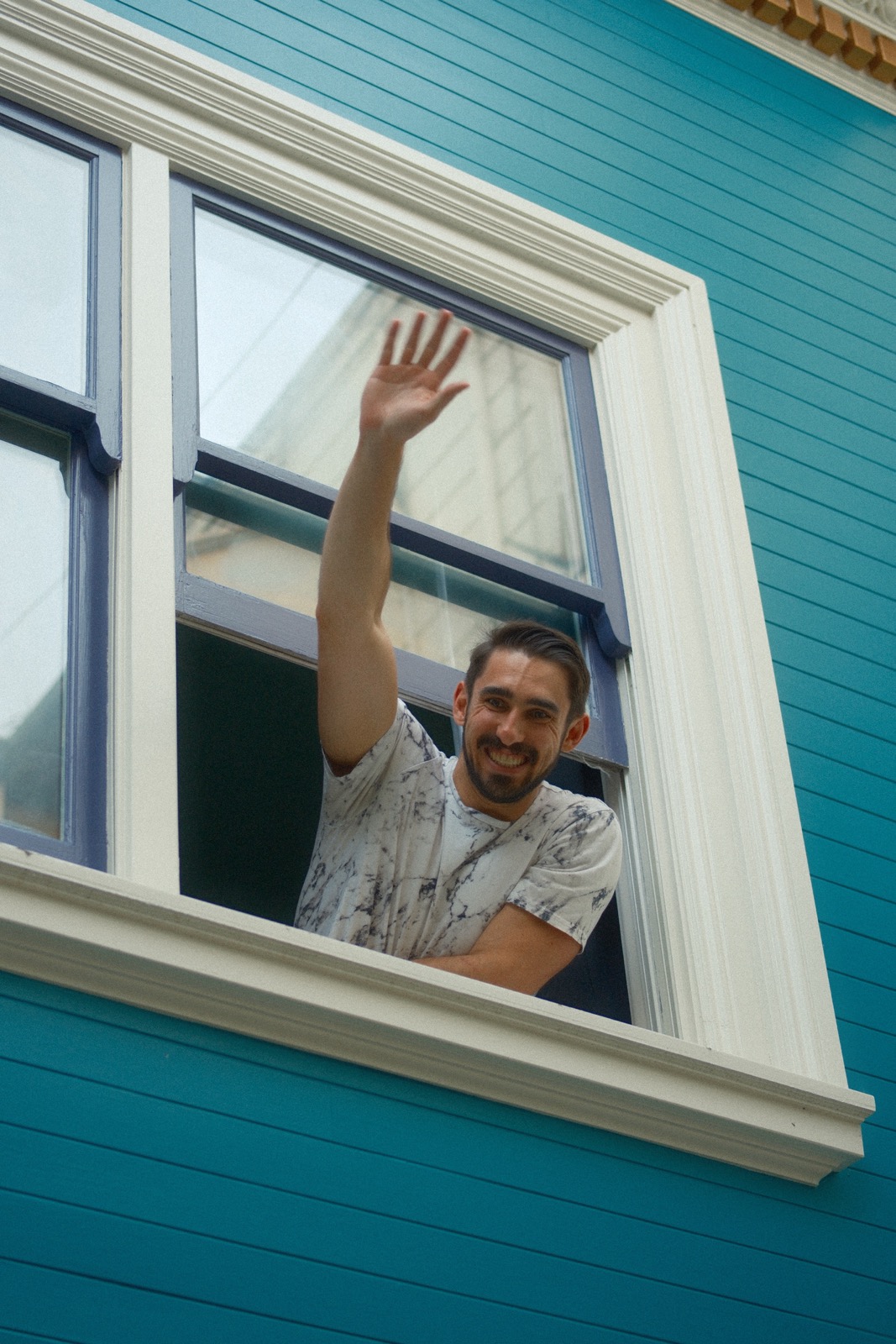 A resident waving from an upstairs window